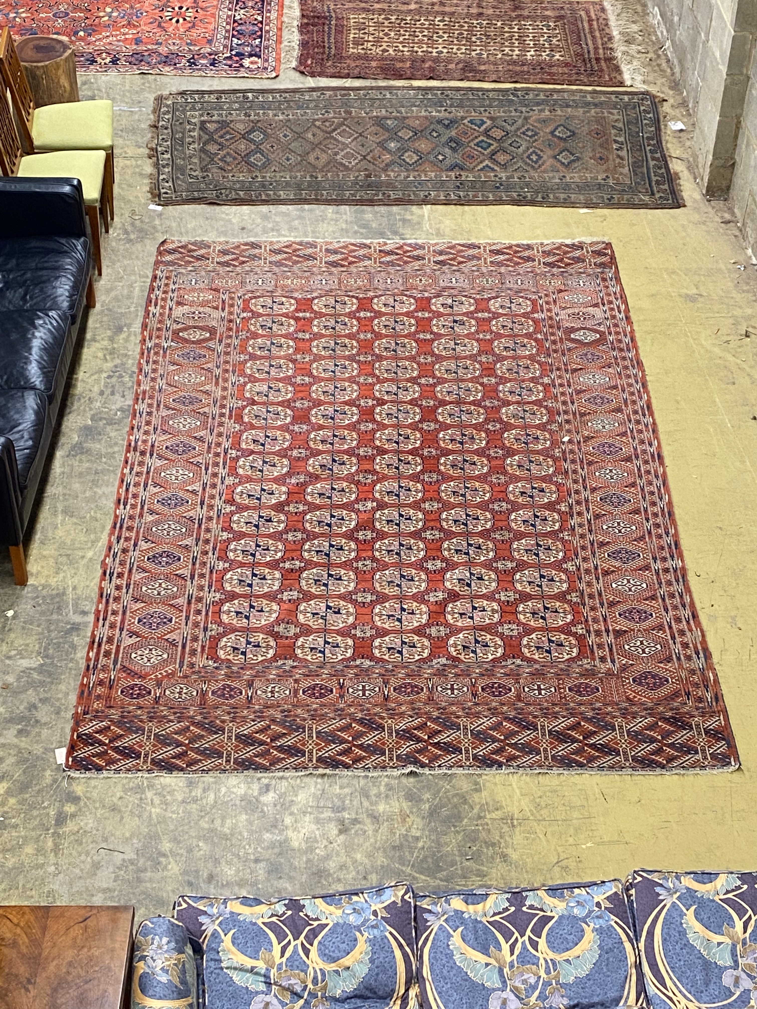 A Bokhara brick red ground carpet, 350 x 230cm